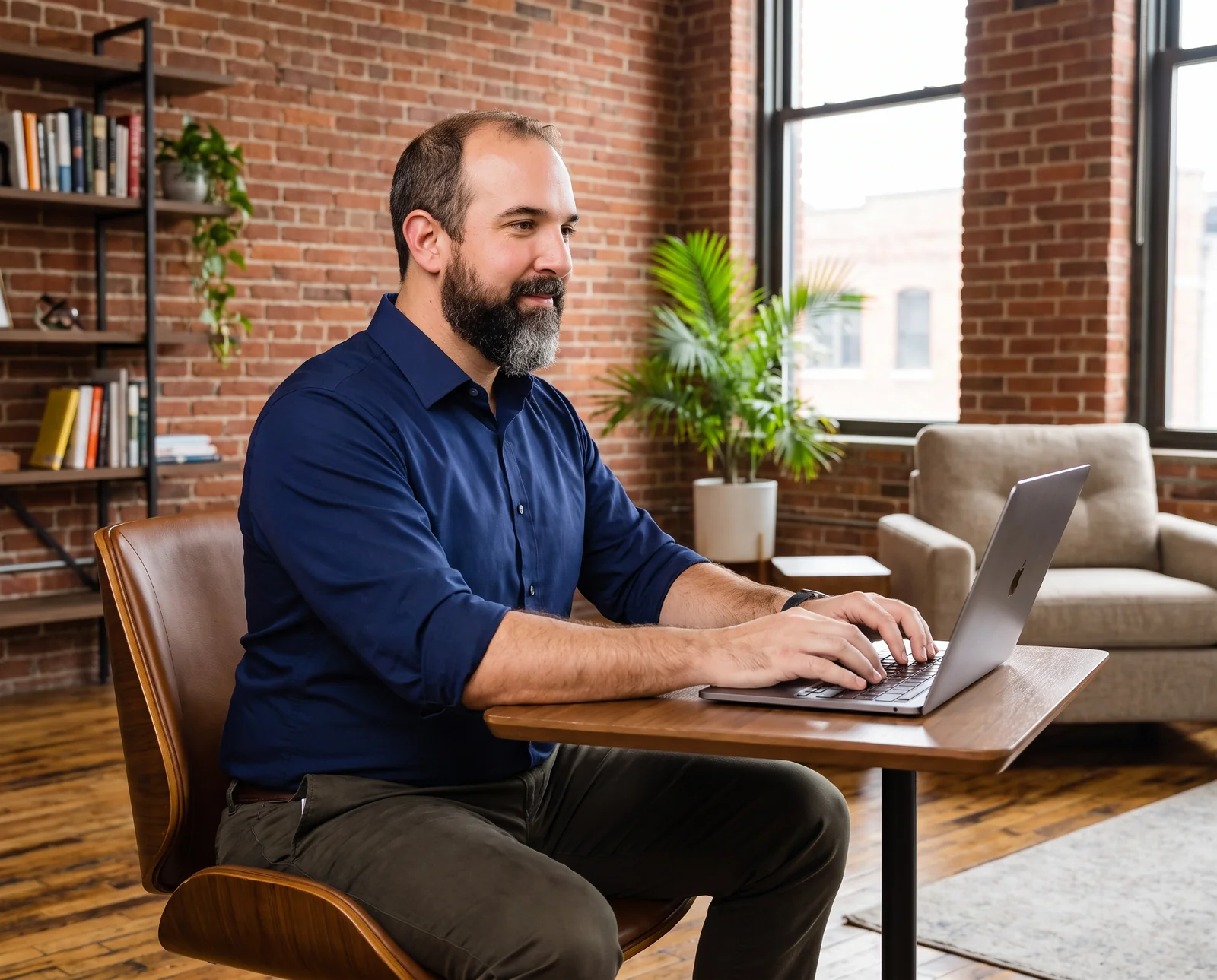 Marketing partner working on a laptop in a brick-walled office