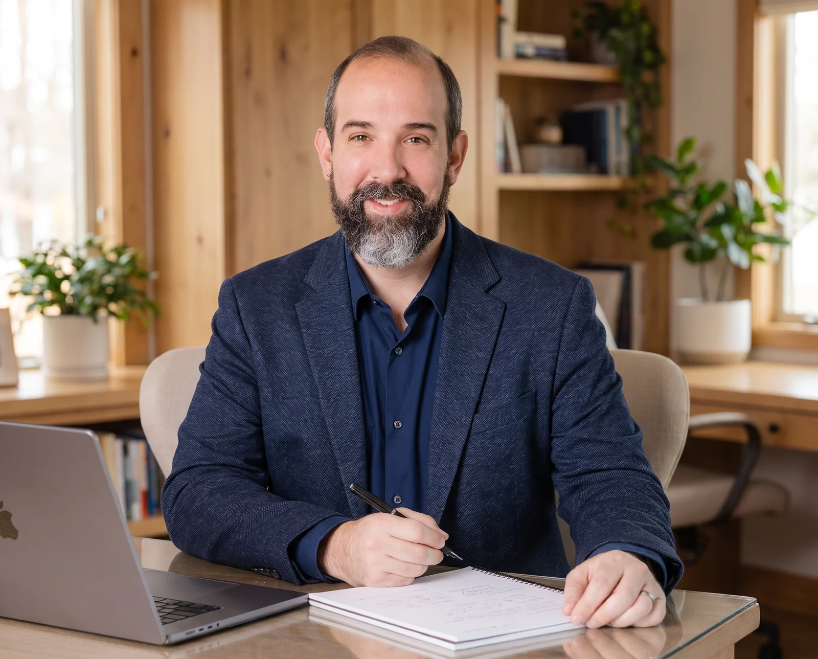 Marketing strategist seated at a desk with a notebook and laptop